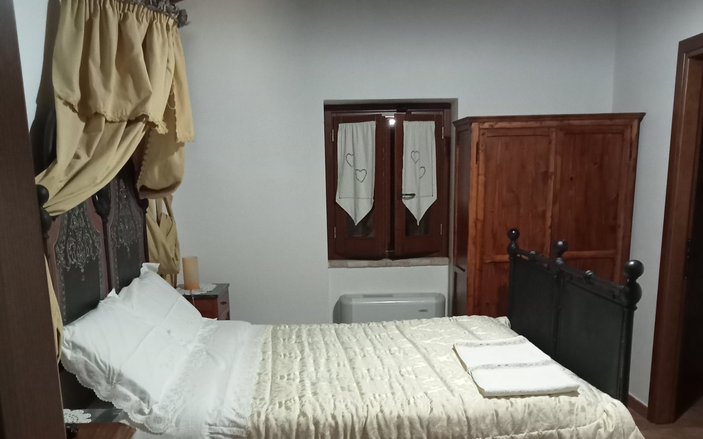Camera del casolare con letto a baldacchino e mobili in legno per il pernottamento con prima colazione ad Assisi
