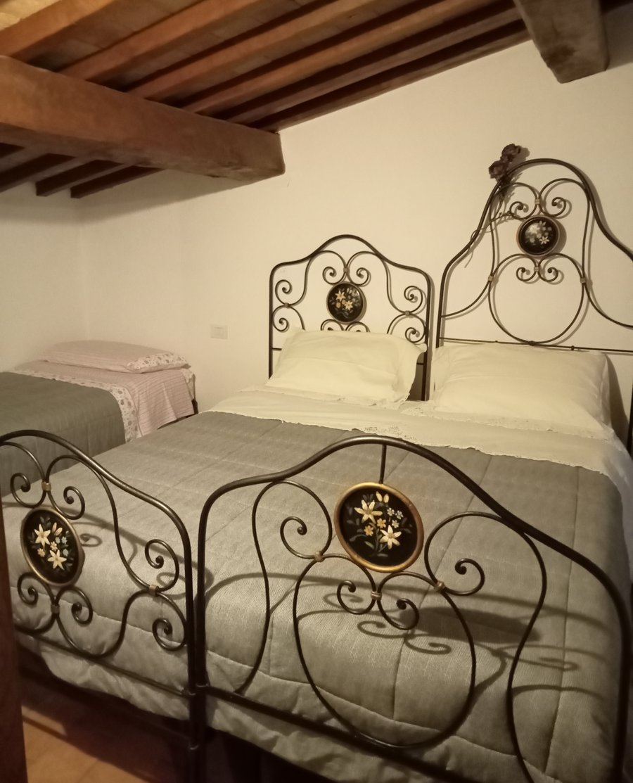 Camera con letto matrimoniale e letto singolo per famiglie in agriturismo vicino ad Assisi