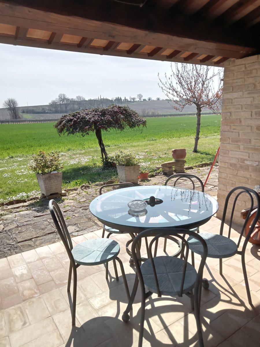 Tavolo sotto il porticato del casolare con vista sulla campagna umbra vicino ad Assisi